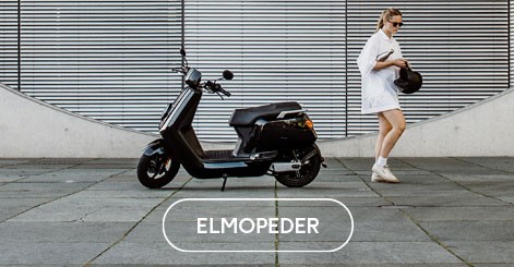 Ung kvinna som åker lekfullt på en silverfärgad moped