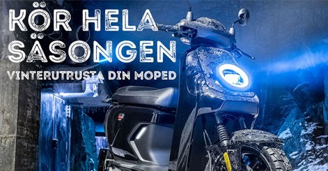 En kvinna kör elmoped i en allé på hösten