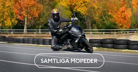 Mycket glad ung man framför en moped, under en bro